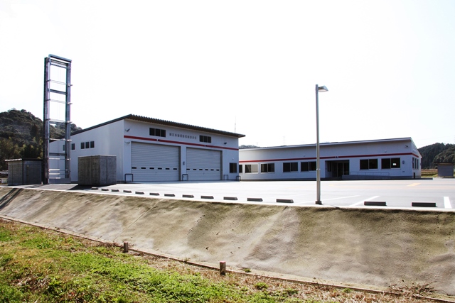 広い駐車場に白壁の車庫などの建物がある南部分署庁舎を北側から写した写真
