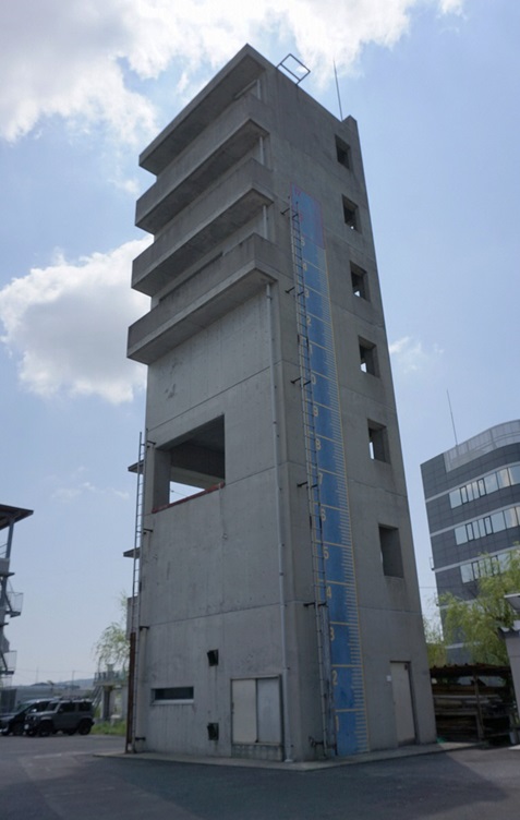 コンクリート7階建て、6か所に四角でくりぬかれた空間がある四角い建物の主訓練棟の写真