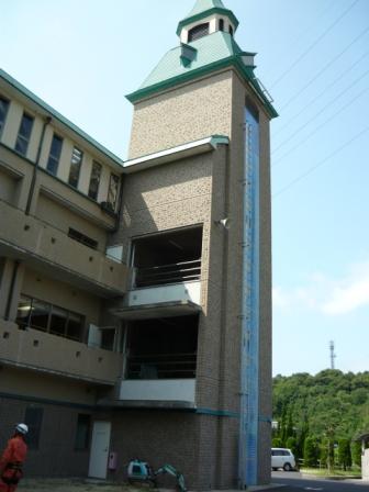 ベージュ色の壁の訓練塔を下から撮影した写真