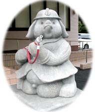 宍道分署入口に設置された消防隊員の格好をしたたぬきの石像の写真