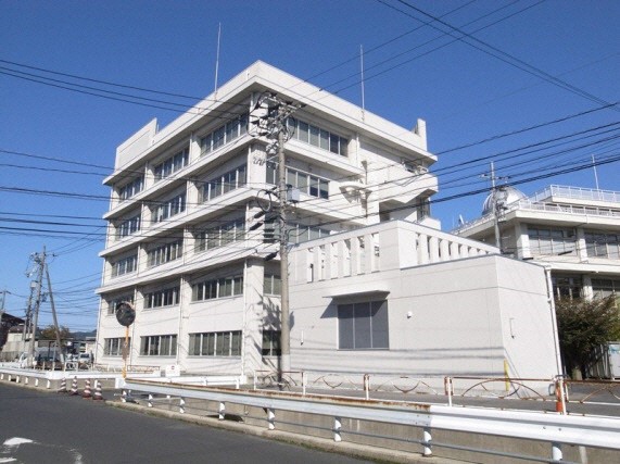 5階建ての外壁が白い西棟を道路から撮影した写真