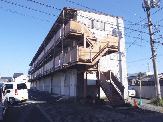 手前に階段があり、横に長い造りをした3階建ての第3別館の建物の写真