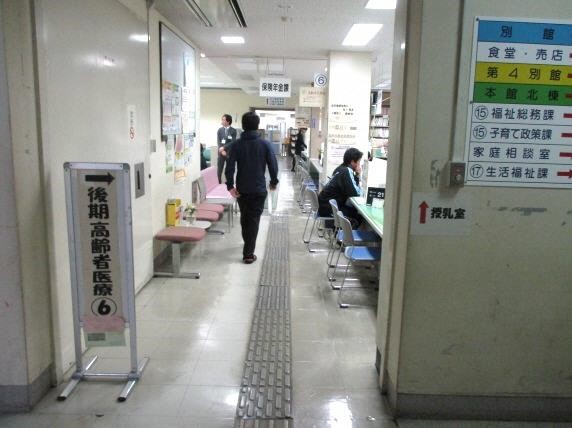 保険年金課窓口に続く狭い通路を来庁者の方が歩いている写真