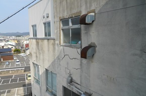 第4別館の窓ガラスの下外壁にひびが入っている写真