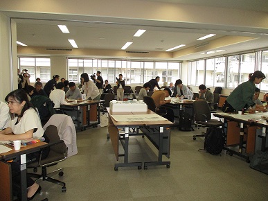 屋内でグループごとに座っている参加者がグループワークを行っている様子の写真