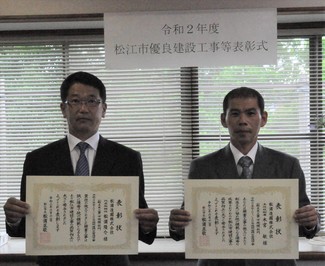 代表取締役の松浦氏と主任技術者の木宮氏が表彰状を手にして並んでいる写真