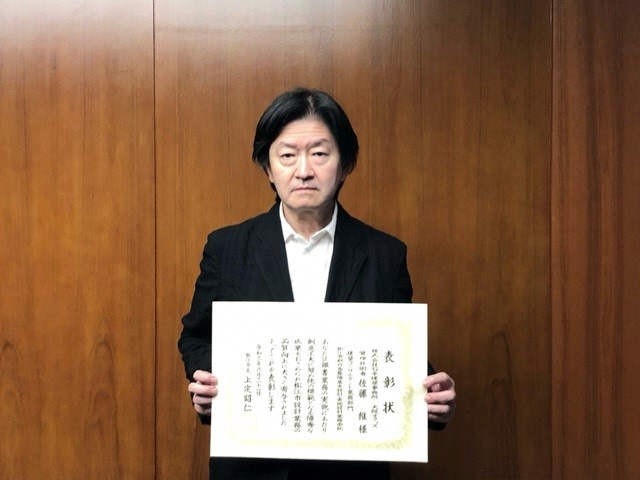 監理技術者の佐藤氏が表彰状を手にして正面に向けている写真