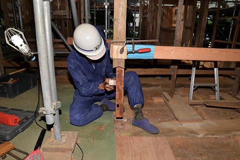 柱の揚屋工事を行っている作業員の写真