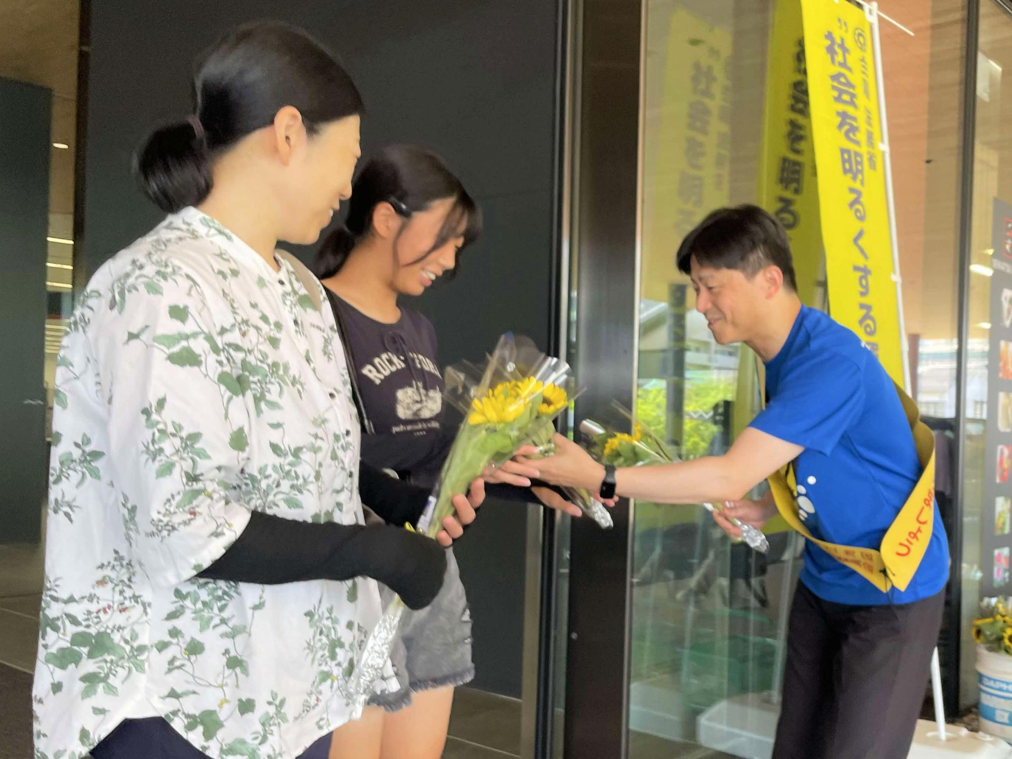 上定市長よりひまわりを受け取る来庁者