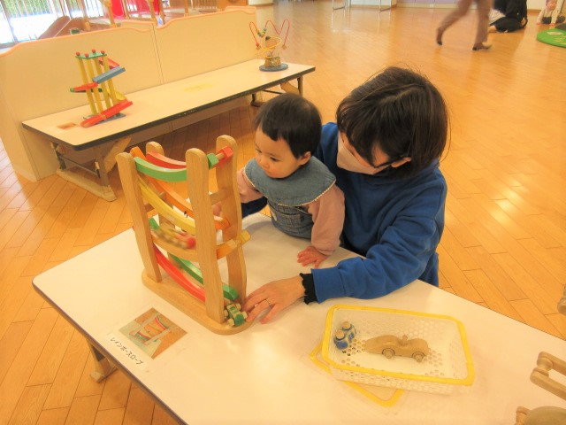 ころころスロープの玩具で遊ぶ親子の写真