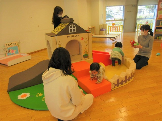 大型遊具のまわりで親子が集まって遊ぶ写真