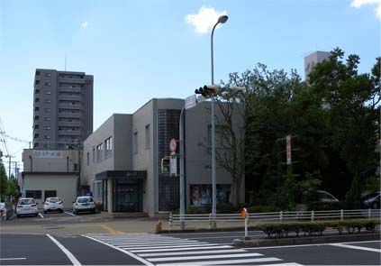 建物前に駐車場があり、グレー系の外壁のアサヒビール株式会社の外観写真