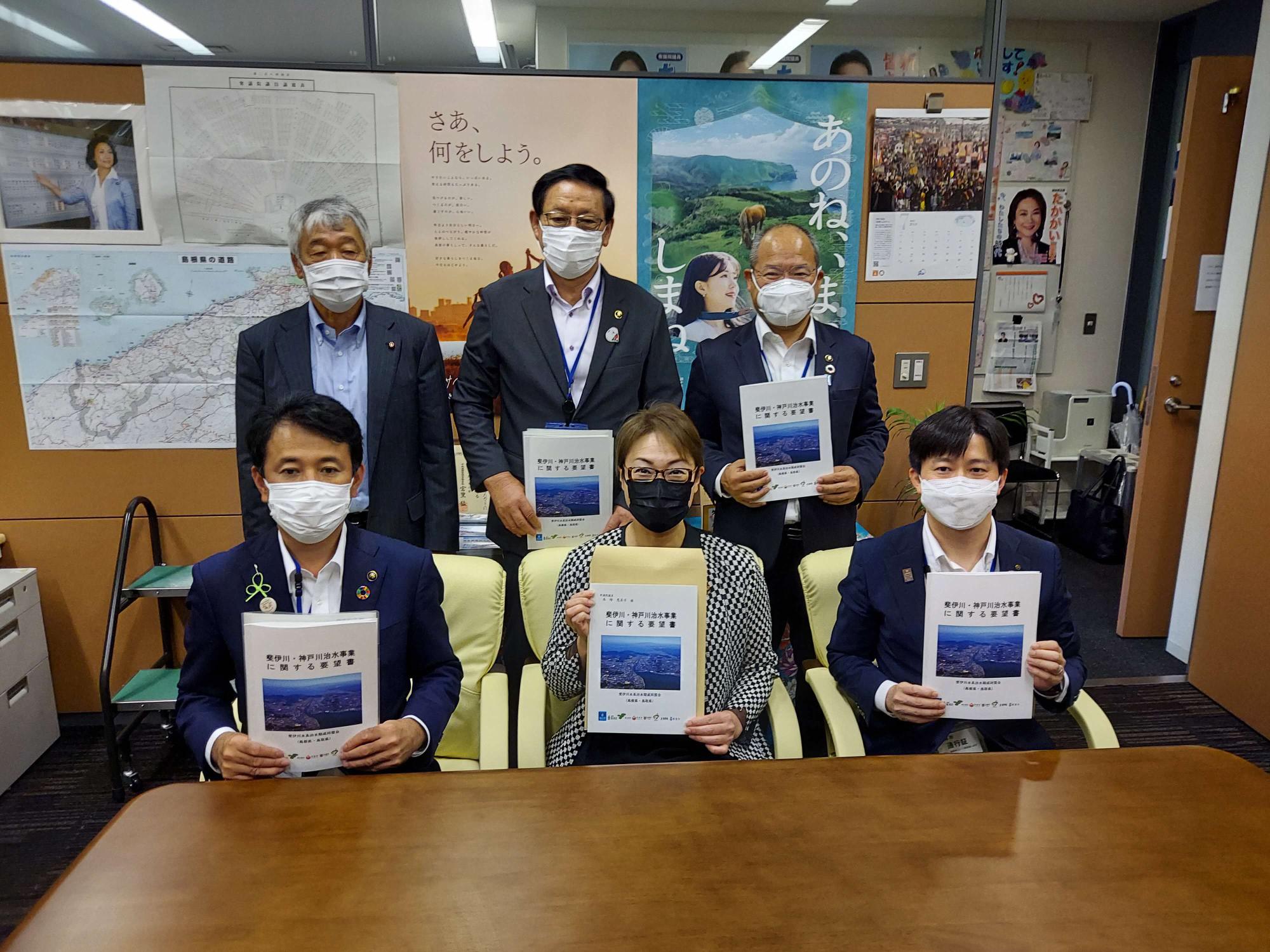 前列に3名椅子に座り中央に高階恵美子衆議院議員、後列に男性3名同盟会の男性おり一緒に要望書を持っている集合写真