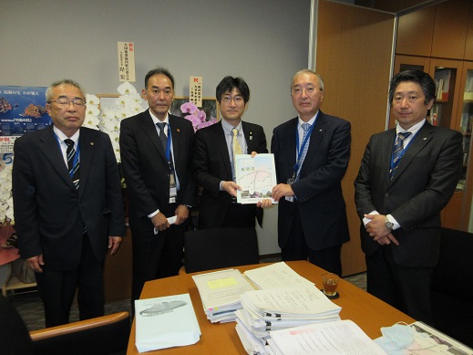 5名の男性が横一列に並び、中央に立つ舞立昇治参議院議員と同盟会の男性が一緒に要望書を持っている集合写真