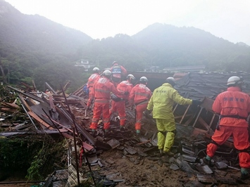 被災地で6名の隊員が横一列になって災害救助を行っている様子の写真