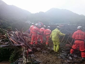 被災地で6名の隊員が横一列になって災害救助を行っている様子の写真