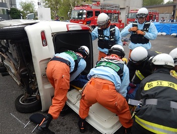 交通事故で横転した自動車を想定した救出訓練を行っている様子の写真