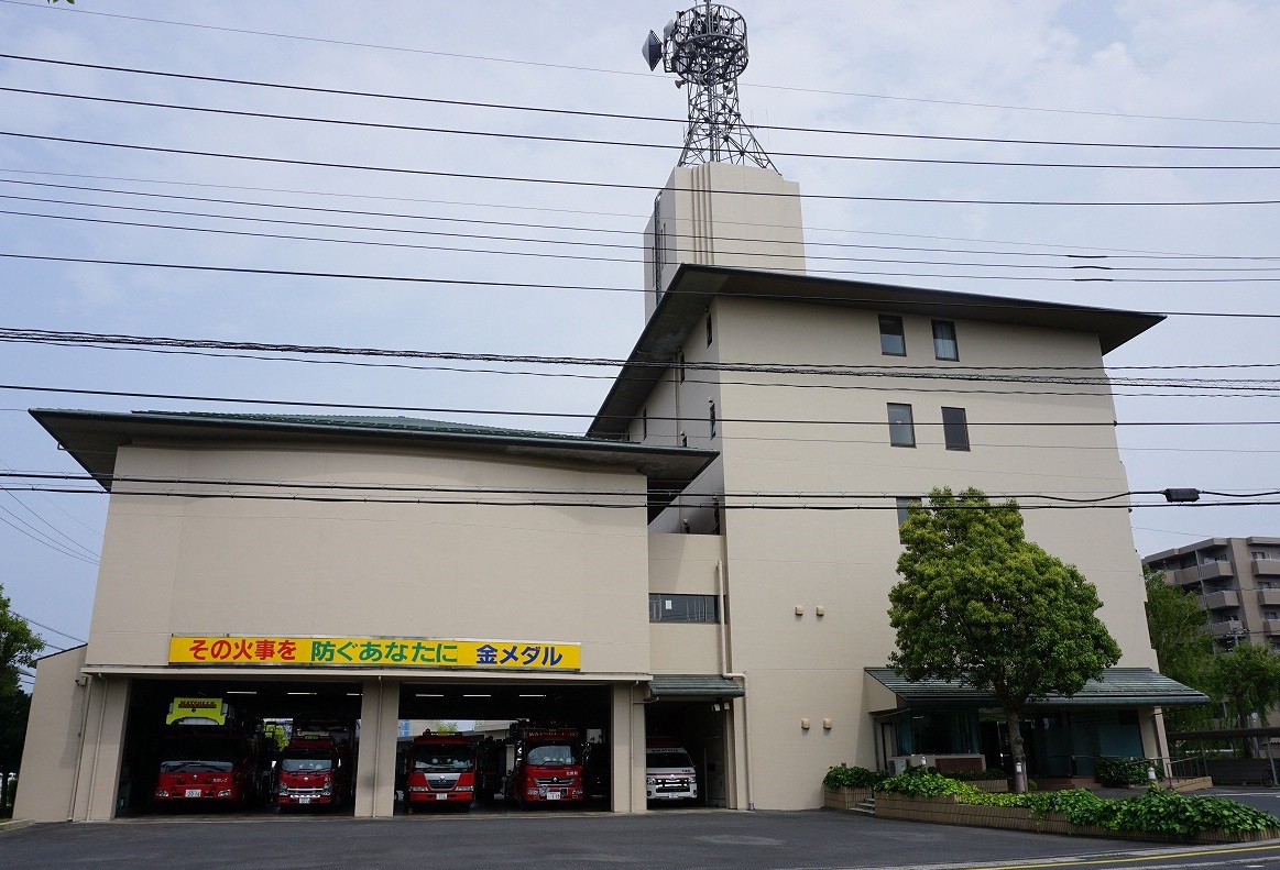 右側に入り口、左側が車庫になっており、消防車4台と救急車1台が駐車されている消防本部の外観を正面から写した写真