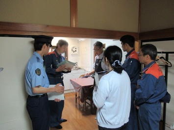 宿泊施設に立ち入って検査を行う警察や消防、県薬事衛生課の三機関の方々の写真