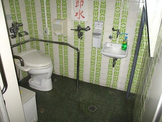 便座の周囲に手すり、手洗い場が設置された多目的トイレ内の写真