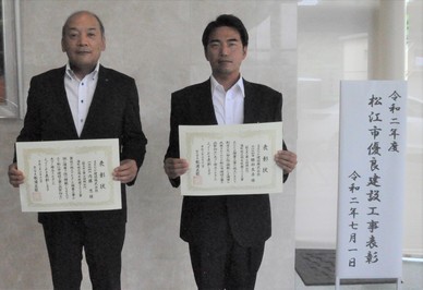 代表取締役の内藤氏と主任技術者の勝部氏が表彰状を手にして並んでいる写真