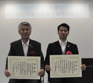 代表取締役社長の川上氏と主任技術者の中島氏が表彰状を手にして並んでいる写真