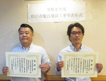 代表取締役の梶野氏と主任技術者の梶野氏が表彰状を手にして並んでいる写真