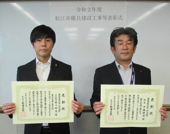 所長の中島氏と主任技術者の野々村氏が表彰状を手にして並んでいる写真