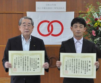 代表取締役の金津氏と監理技術者の水野氏が表彰状を手にして並んでいる写真