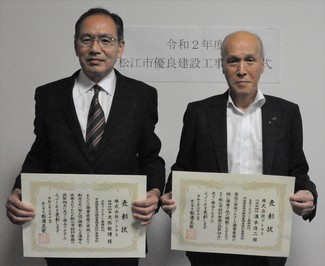 代表取締役の溝本氏と管理技術者の大掛氏が表彰状を手にして並んでいる写真
