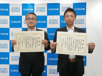 代表取締役社長の平塚氏と監理技術者の原氏が表彰状を手にして並んでいる写真