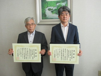 代表取締役の深田氏と主任技術者の星野氏が表彰状を手にして並んでいる写真