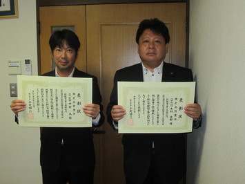 代表取締役の木村氏と主任技術者の中村氏が表彰状を手にして並んでいる写真