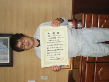 表彰状を持って正面に向けている山陰クボタ水道用材株式会社の門脇崇之氏の写真