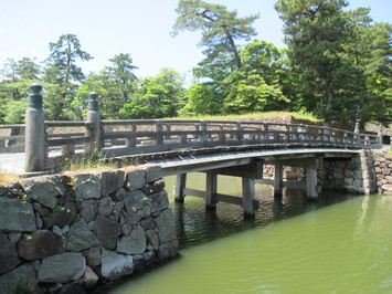 池の上にかかっている修繕された北惣門橋の写真