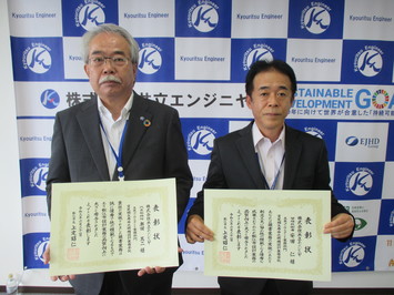代表取締役の奥田氏と管理技術者の安田氏が表彰状を手にして並んでいる写真