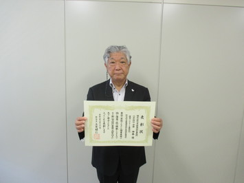 小草建築設計事務所の代表取締役の小草氏が表彰状を手にして正面に向けている写真