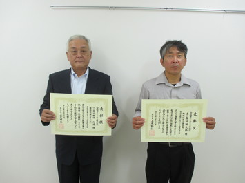 代表取締役の櫛田氏と主任技術者の池田氏が表彰状を手にして並んでいる写真