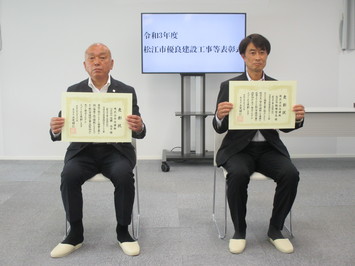 代表取締役の佐藤氏と監理技術者の飯塚氏が表彰状を手にして並んでいる写真