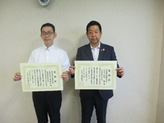 代表取締役社長の新田氏と監理技術者の岡本氏が表彰状を手にして並んでいる写真