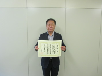 矢野建築設計事務所の代表取締役の矢野氏が表彰状を手にして正面に向けている写真