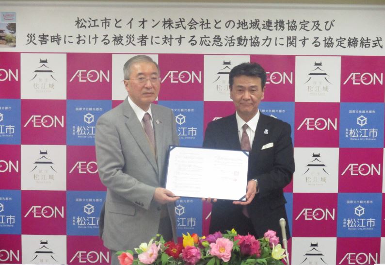 協定締結式の会場で、浜口支社長と松浦松江市長が一緒に協定書を持っている写真