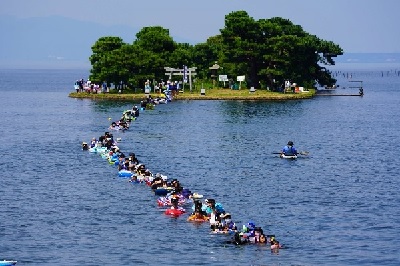 水に浸かりながら列をなして嫁ヶ島に渡っている参加者の写真