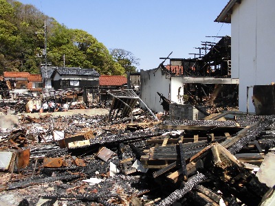 たくさんのがれきと焼損し壁や天井がなくなっている建物が並んでいる写真