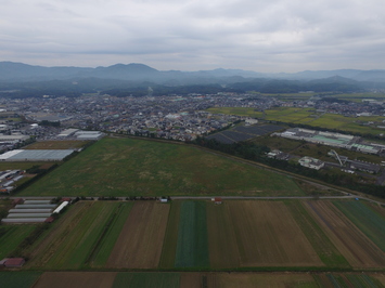 奥に山々や街並みが広がる揖屋干拓工業団地を上空から撮影した写真