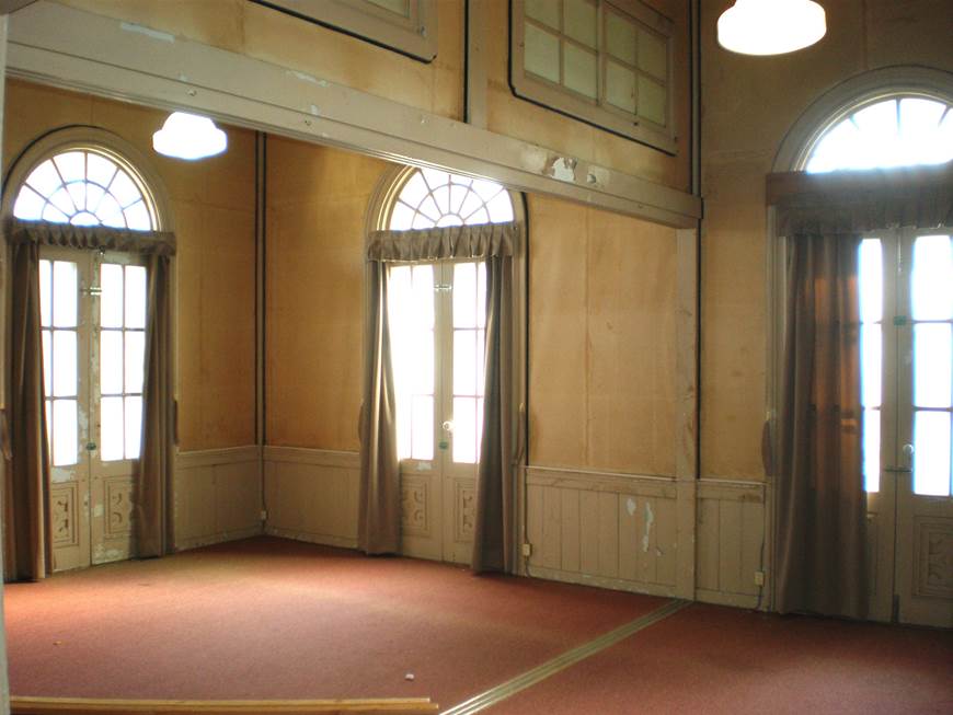 床に赤い絨毯が敷かれ、ガラスの扉から外の光が差し込んでいる興雲閣2階貴顕室の写真
