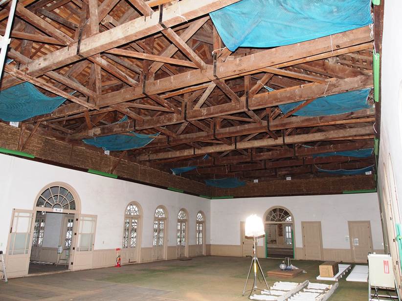 解体された天井の一部にブルーのネットがかけられている興雲閣2階大広間の写真