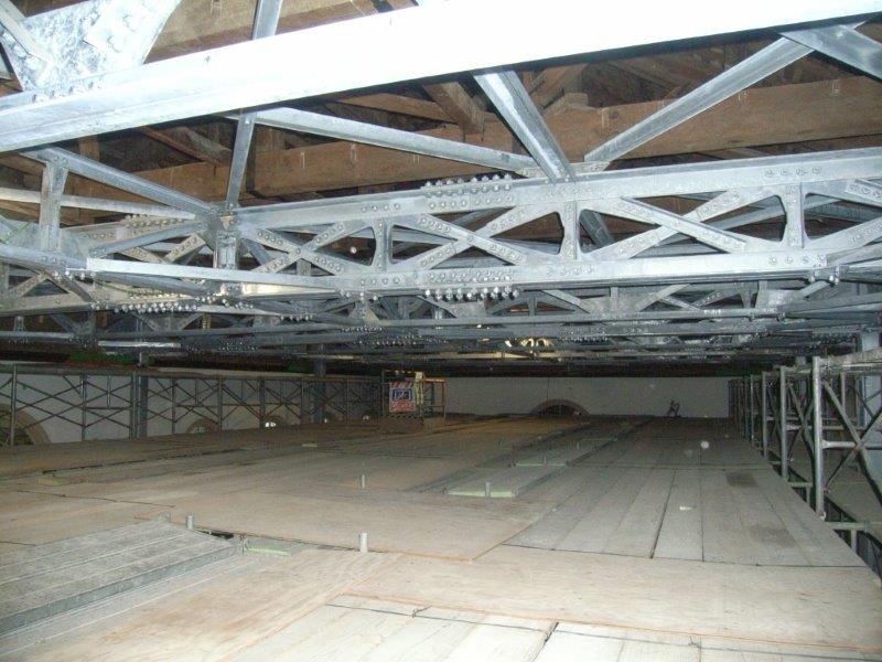 天井の梁に沿って耐震補強用の鉄骨が組まれている天井裏の写真
