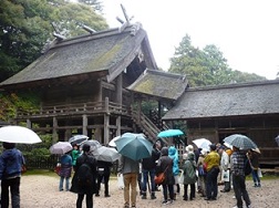 神魂神社の社殿を傘をさしながら見学している参加者の写真