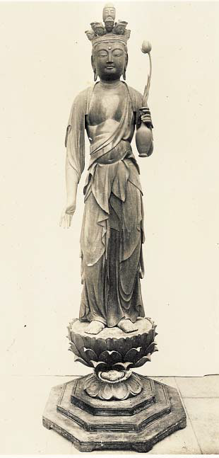 左手には、未敷蓮華を挿した水瓶を持ち、右手はまっすぐ下に垂れて頭上には十一面の仏さまの顔が配置されている木造十一面観音立像の写真